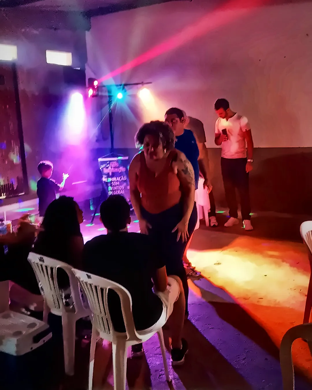 Convidados na pista sob luzes coloridas